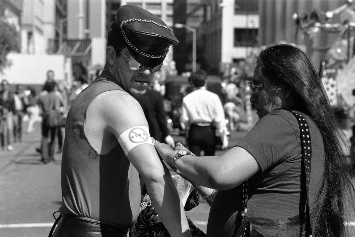 A man gets a "No AIDS" armband wrapped around his arm at the Gay Freedom Day Parade in San Francisco in 1983. (Eric Risberg / Associated Press)