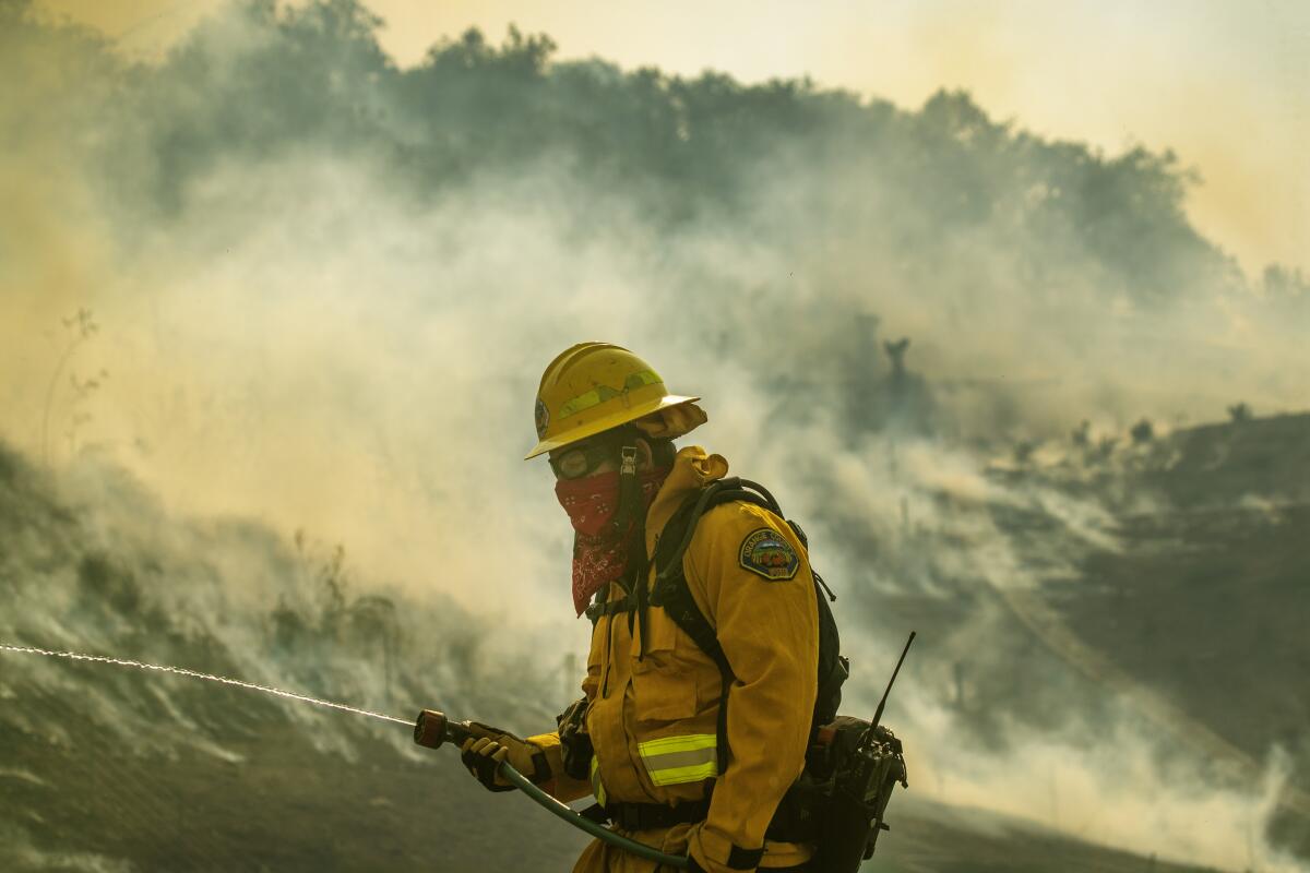 An Orange County Fire Authority firefighter uses a resident's garden hose.