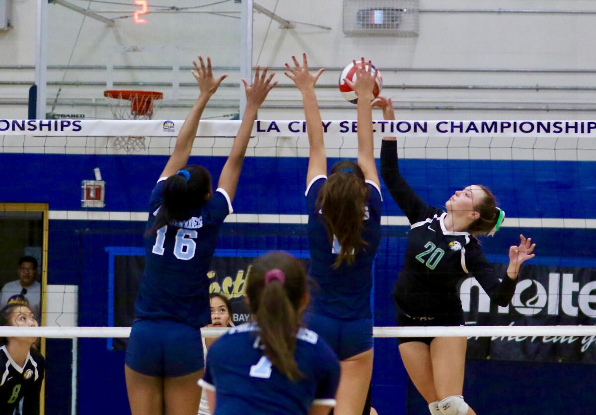 Eagle Rock's Wendy Jurenec (20) attempts a spike against Palisades during the City Section Open Division girls' volleyball championship match at Birmingham.