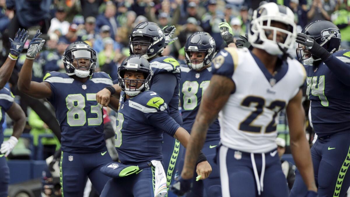 Rams cornerback Marcus Peters, 22, walks away in disgust as the Seahawks celebrate a touchdown reception by David Moore, 83. 