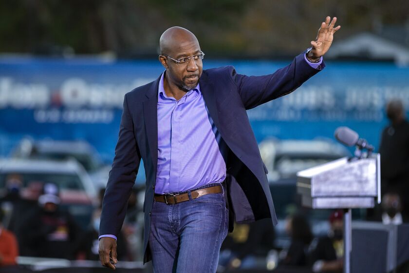 Democratic U.S. Senate candidate Rev. Raphael Warnock waves to supporters during a drive-in rally, Sunday, Jan. 3, 2021, in Savannah, Ga. Vice President-elect Kamala Harris made a campaign stop for Georgia candidates Warnock and Jon Ossoff before the runoff election Tuesday. (AP Photo/Stephen B. Morton)