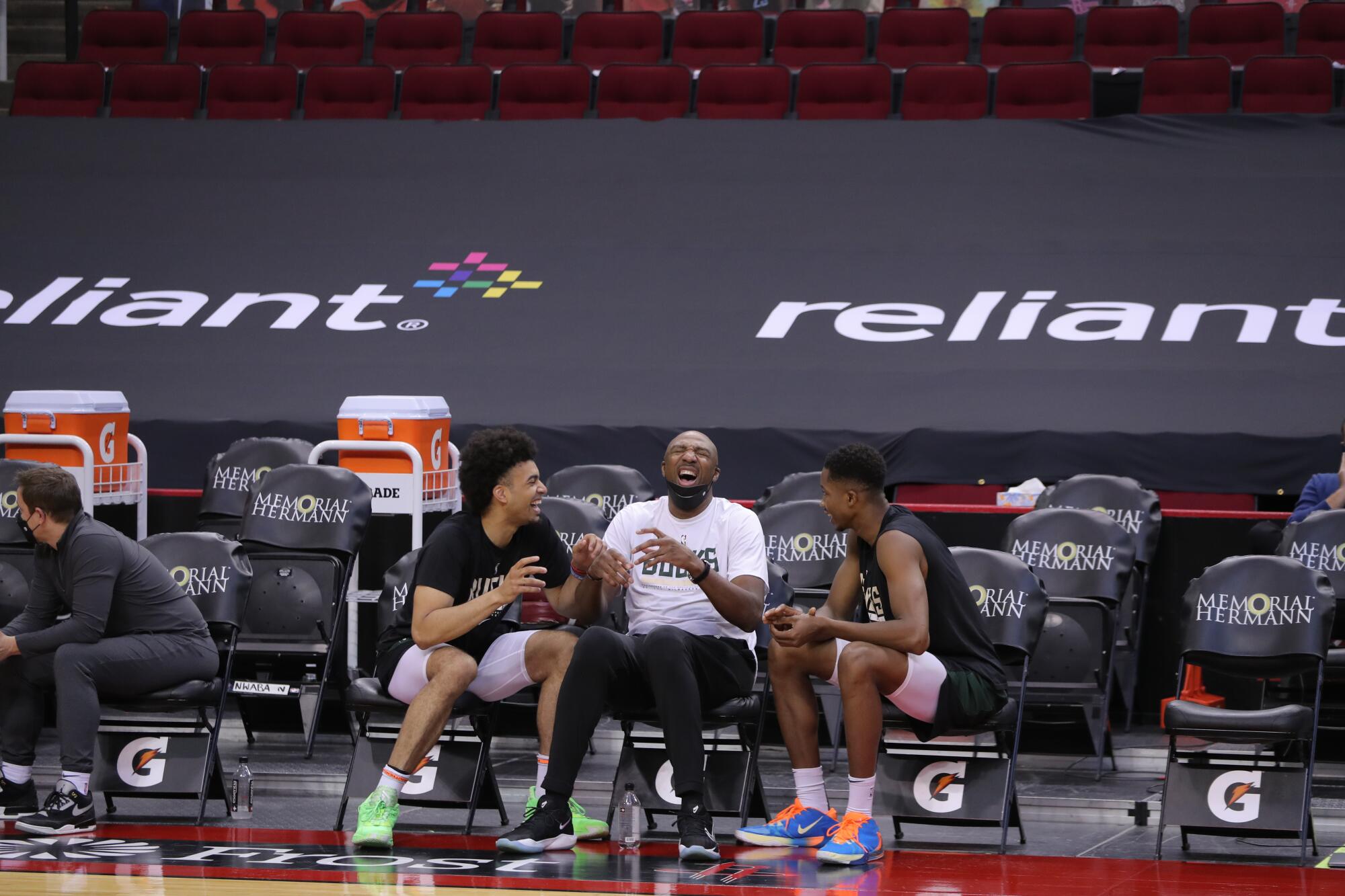Bucks assistant coach Vin Baker, center, shares a laugh with players during a practice in Houston.