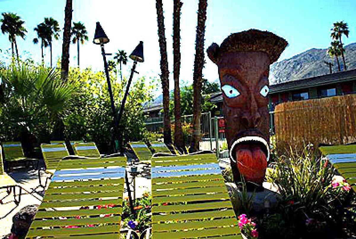 The pool and courtyard at the Caliente Tropics motel are adorned with island-themed statues.