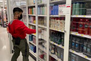 Target employee stocking personal hygiene items in new locked security shelving, Target, Queens, New York. (Photo by: Lindsey Nicholson/UCG/Universal Images Group via Getty Images)