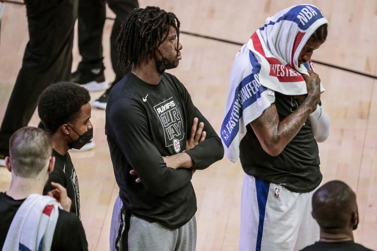 Clippers guard Paul George, right, looks on during a time out in Game 1.