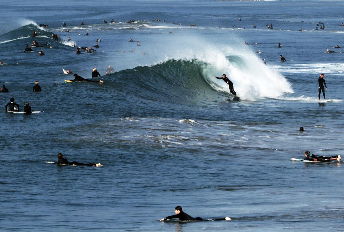 Hundreds of surfers take advantage of swells that are well over 6 feet.