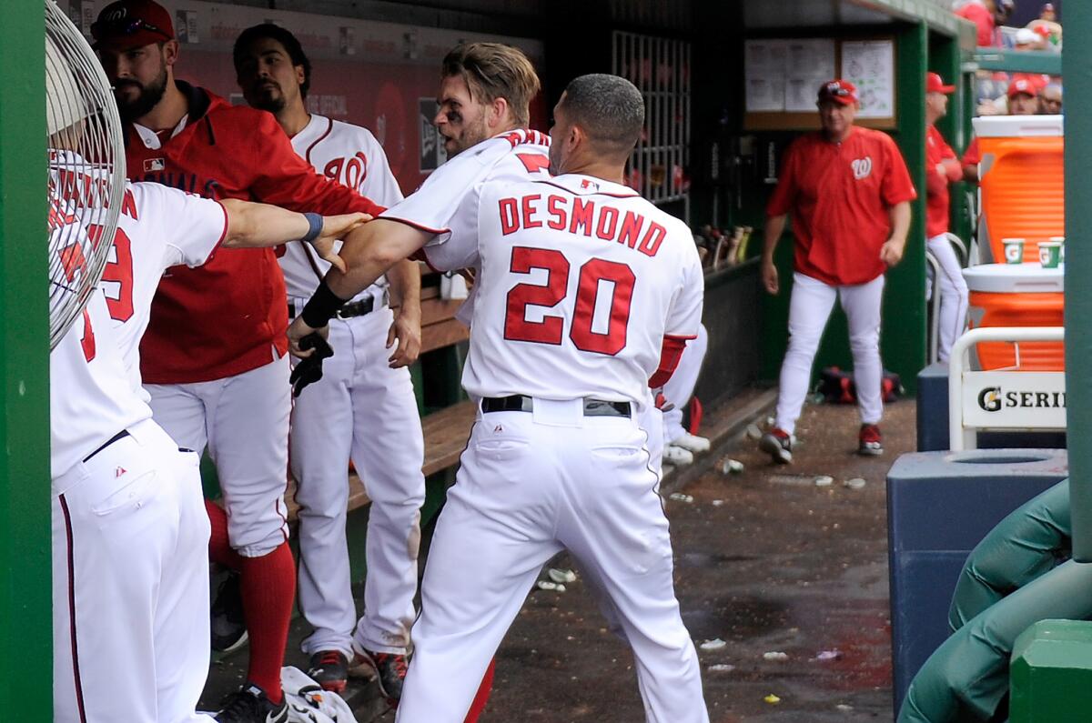 Washington's Bryce Harper is pulled away by Ian Desmond during an altercation with Jonathan Papelbon in the eighth inning against Philadelphia on Sunday.