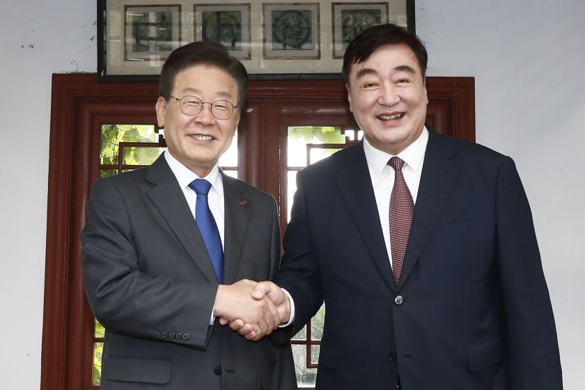 Chinese Ambassador to South Korea Xing Haiming, right, shakes hands with South Korea's main opposition Democratic Party leader Lee Jae-myung before their dinner meeting at the Chinese ambassador's residence in Seoul, South Korea, Thursday, June 8, 2023. South Korea’s Foreign Ministry summoned China's ambassador on Friday to protest comments he made accusing Seoul of tilting toward the United States and away from China, as competition between Washington and Beijing for global influence intensifies.(Yonhap via AP)