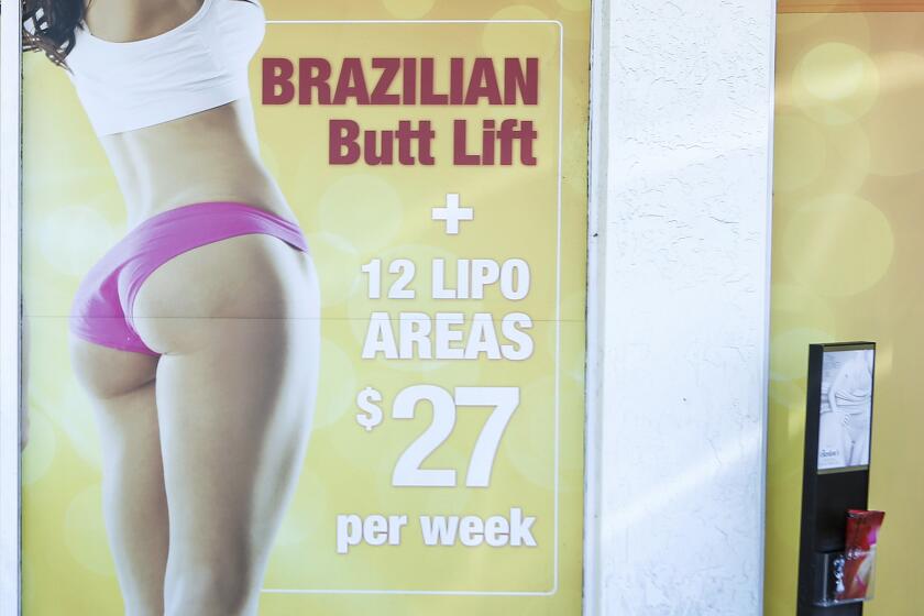 Un cartel anuncia una cirugía cosmética de "levantamiento de glúteos brasileño" en una clínica de Miami, el viernes 22 de marzo de 2019. (AP Foto/Ellis Rua, Archivo)