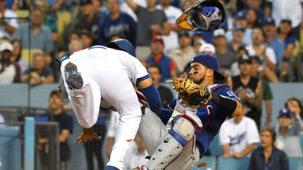 Dodgers' Matt Kemp (27) is out at the plate as he collides with Texas Rangers' Robinson Chirinos (61) in the third inning at Dodger Stadium on Wednesday.