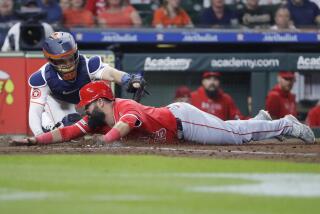 Houston Astros catcher Yainer Diaz, left, is late with the tag as Los Angeles Angels' Luis Guillorme scores during the fourth inning of a baseball game Tuesday, May 21, 2024, in Houston. (AP Photo/Michael Wyke)