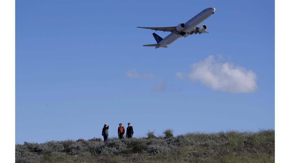A jetliner takes off over the LAX Dunes Preserve at the western end of the airport as scientists look for burrowing owls.