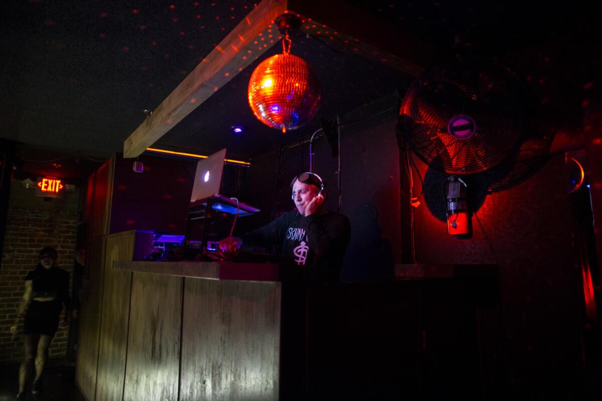 A DJ spins records in between performances on the top level at Los Globos.