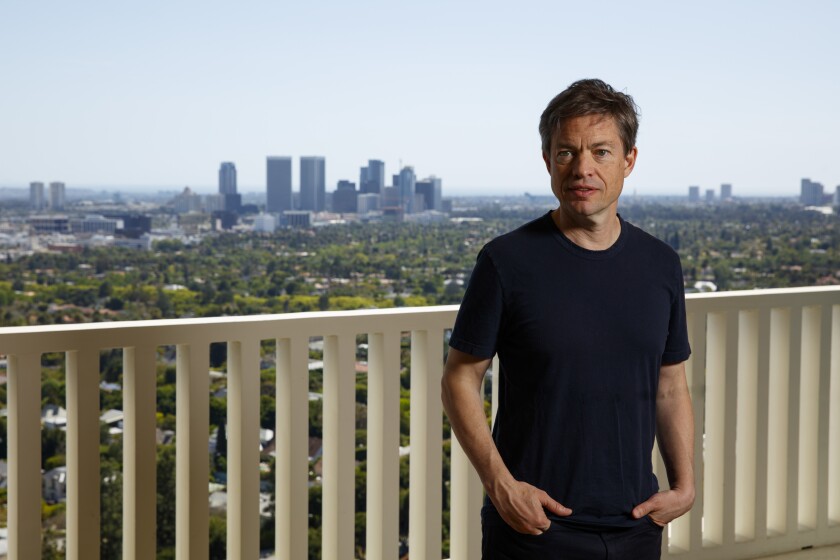 This photo shows a man with views of the city behind.