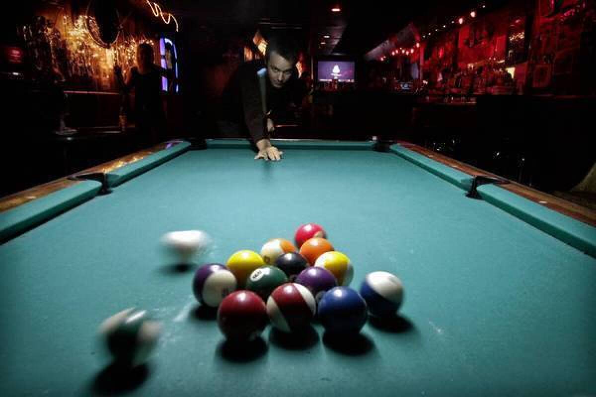 Jordan Lee shoots pool at the Smog Cutter in Los Angeles.