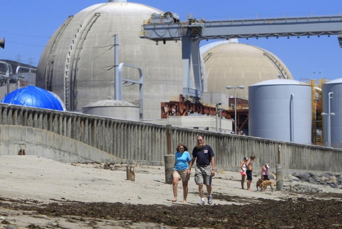 Southern California Edison Co. is arguing that customers should help pay for the cost of closing the San Onofre nuclear power plant in San Diego County. Above, beachgoers near the plant.