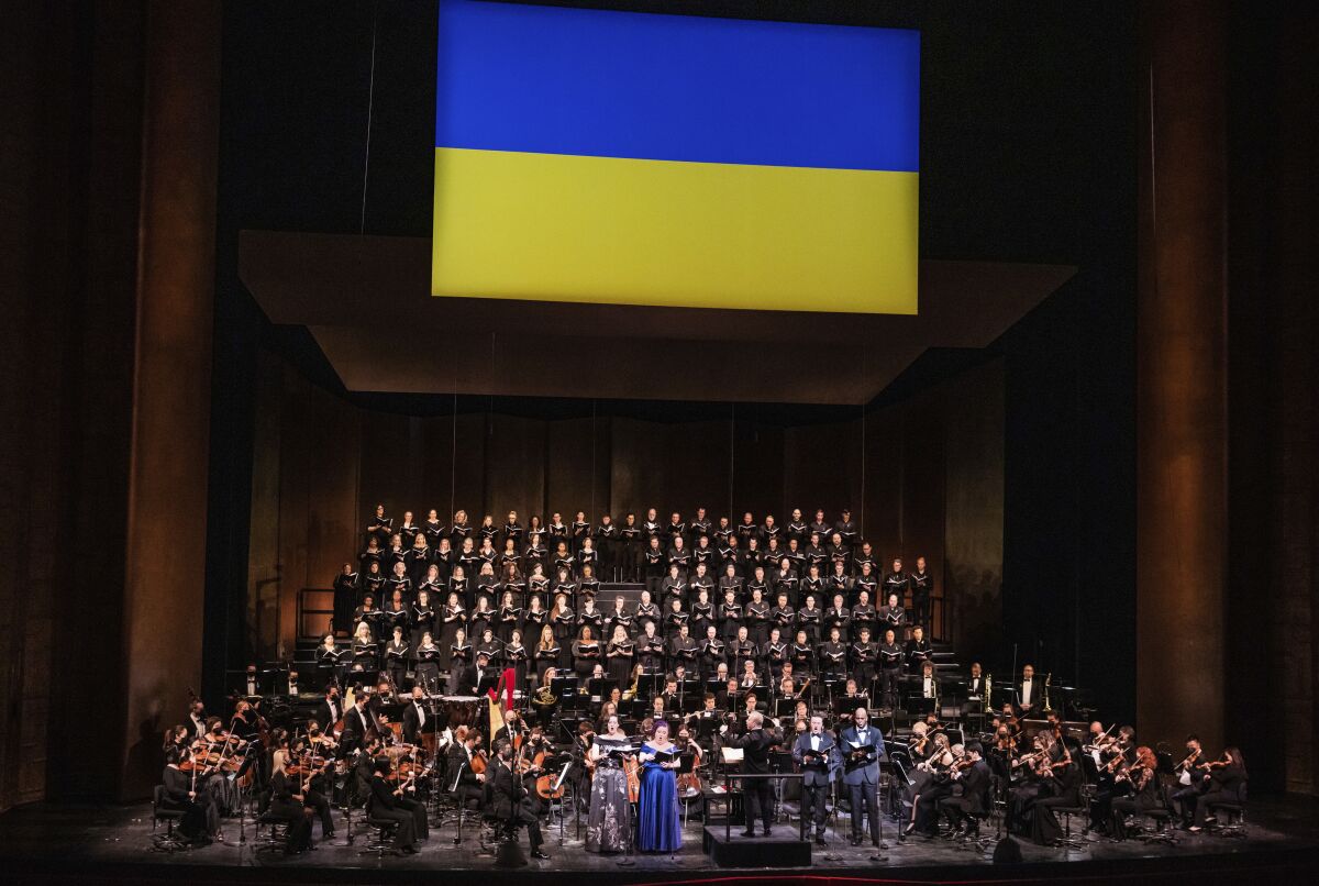 This image released by the Metropolitan Opera shows the Met Orchestra and Chorus in "A Concert for Ukraine" at the Metropolitan Opera on March 14, 2022. With three huge yellow-and-blue Ukraine flags draped across the front of the house, the Met held a benefit for the under-attack nation. (Evan Zimmerman/Metropolitan Opera via AP)