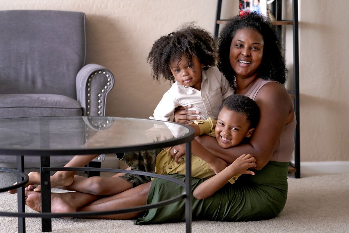 Kisha Gulley appears with her sons Sebastian, 2, left, and Santana, 5, Friday, Sept. 3, 2021 in Phoenix. Gulley is an Instagram influencer and blogger who generates income from her content. (AP Photo/Matt York)
