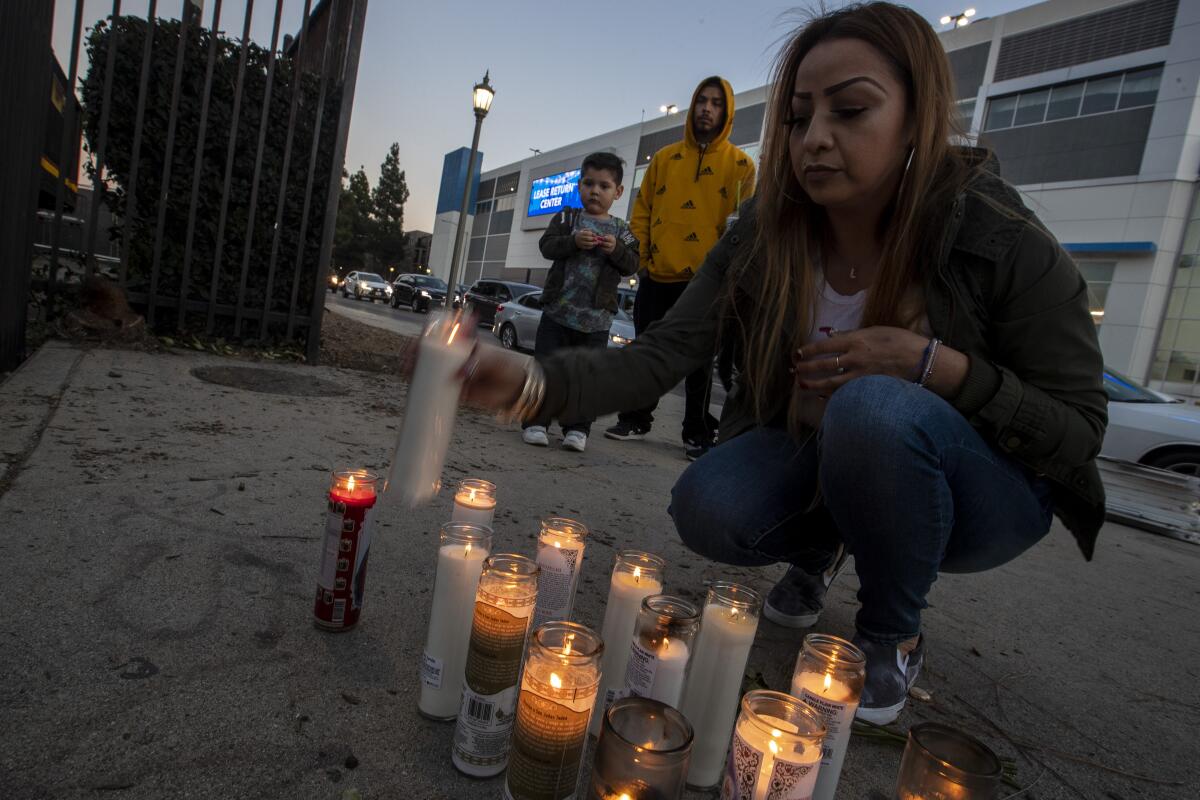 Laura Chavez lights a candle in honor of slain rapper Drakeo the Ruler.