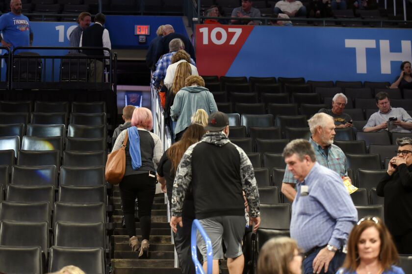 Basketball fans leave Chesapeake Energy Arena after it is announced that an NBA basketball game.
