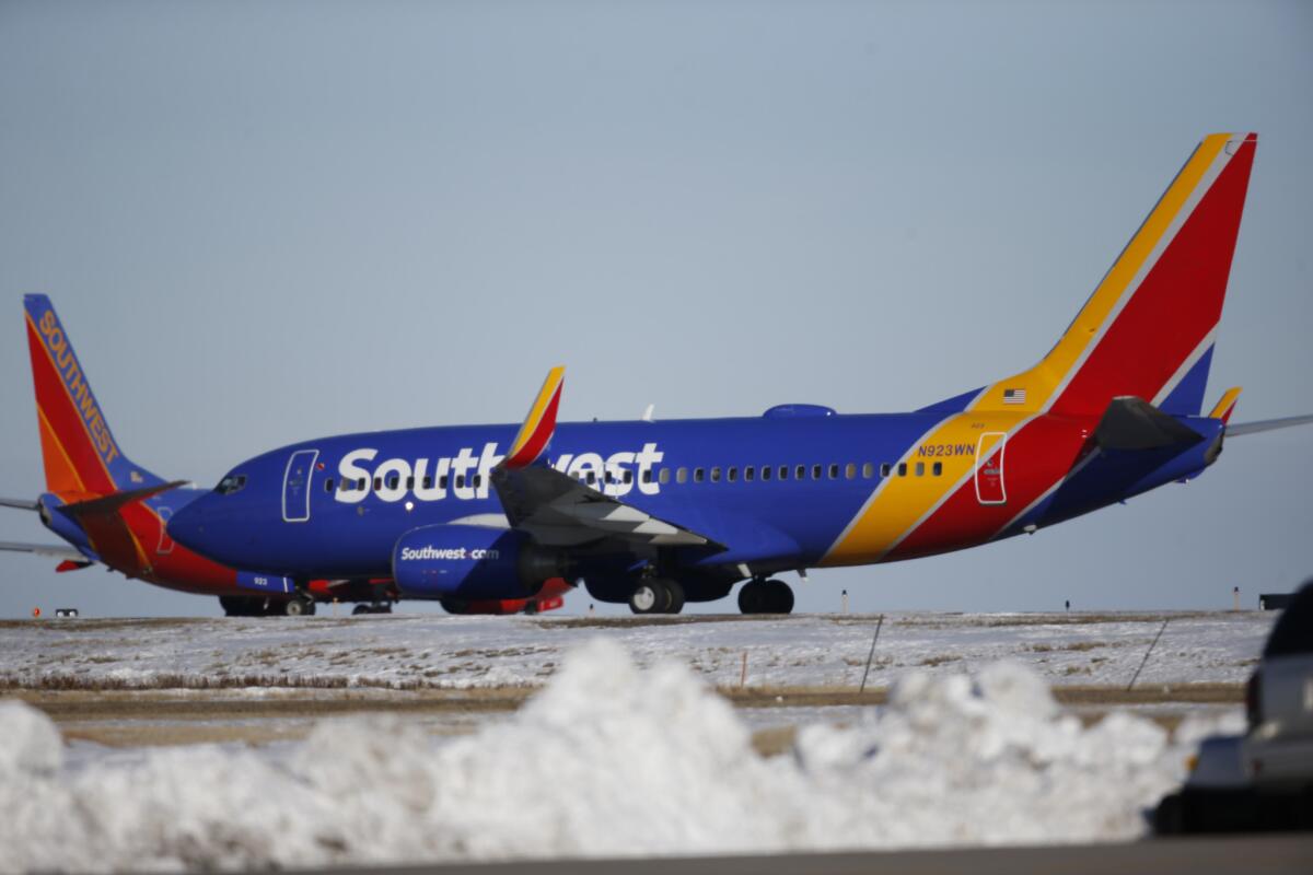 In this photograph taken late Monday, Feb. 8, 2016, Southwest Airlines crafts wait to take off from a runway at Denver International Airport.