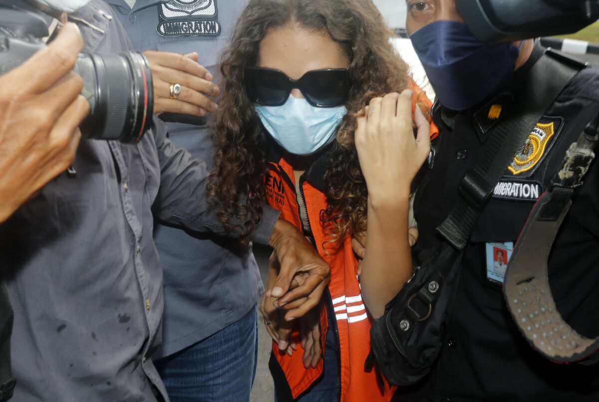 FILE - Heather Mack of Chicago, Ill., center, escorted by immigration officers to Immigration detention center in Jimbaran, Bali, Indonesia on Friday, Oct. 29, 2021. Indonesian authorities on Tuesday, Nov. 2, 2021, announced that Mack, an American woman convicted of helping to kill her mother on Indonesia's tourist island of Bali in 2014, has left the island to be deported to the United States after serving seven years of a 10-year sentence. (AP Photo/Firdia Lisnawati, File)