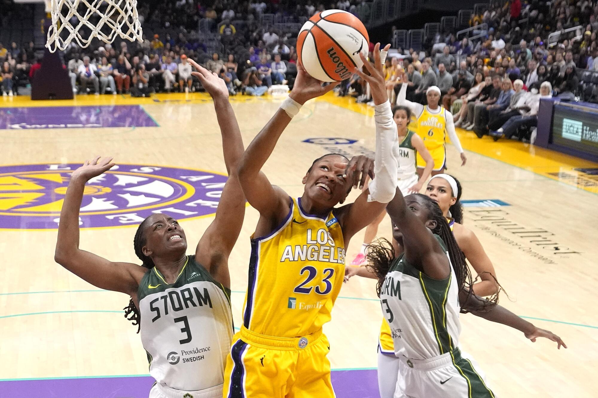 Sparks forward Azura Stevens shoots under pressure from Seattle's Nneka Ogwumike and Ezi Magbegor