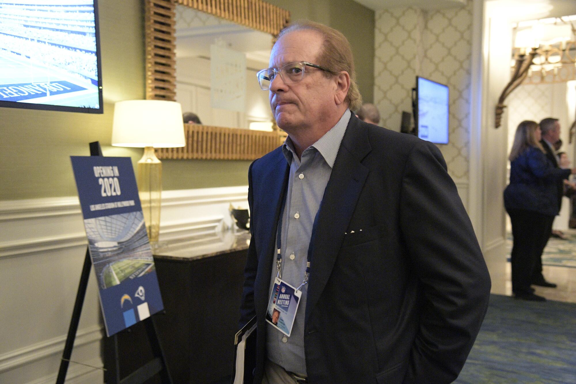 Chargers owner Dean Spanos leaves a conference room during the NFL owners meetings.