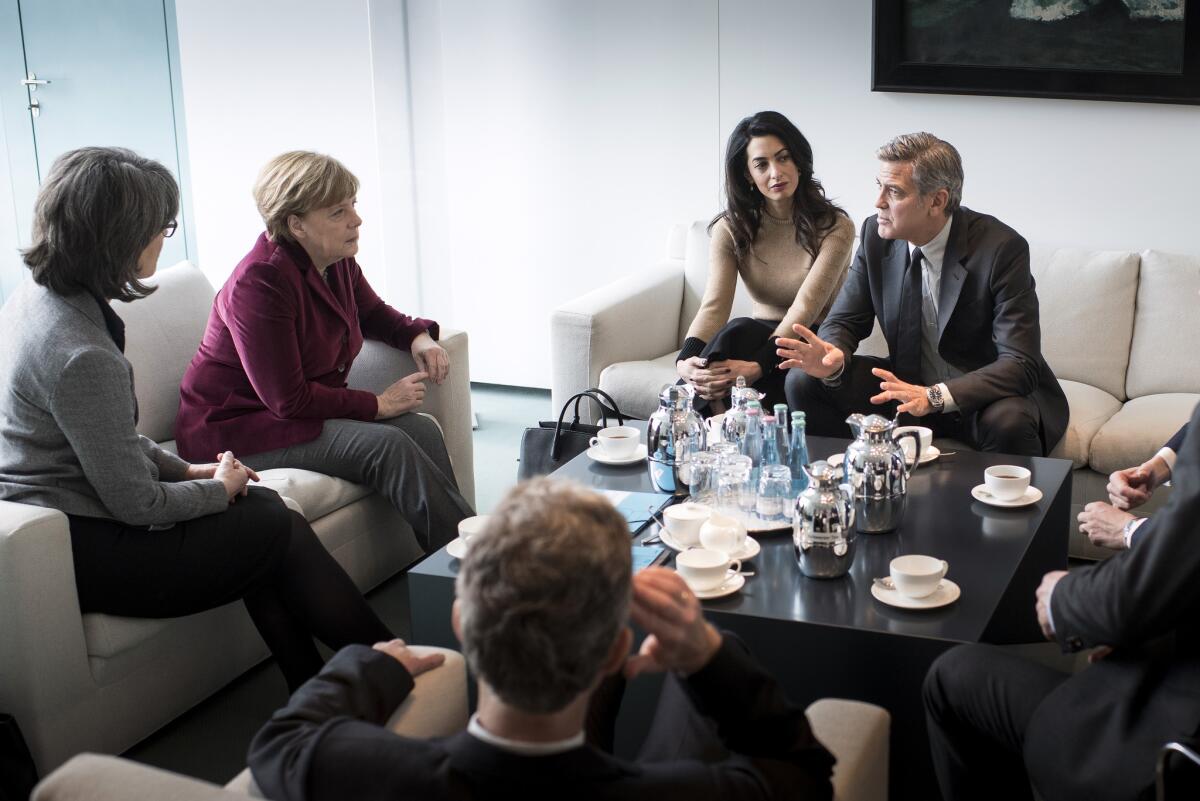 Chancellor Angela Merkel, second from left, meets with Amal and George Clooney and others in Germany on Friday.