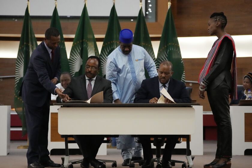FILE - Lead negotiator for Ethiopia's government, Redwan Hussein, left, and lead Tigray negotiator Getachew Reda, right, sign documents during the peace talks in Pretoria, South Africa on Nov. 2, 2022. Eritrean troops and forces from the Amhara region, who have been fighting on the side of Ethiopia's federal military in the Tigray conflict, have been looting property and carrying out mass detentions in Tigray in Nov. 2022, according to eyewitnesses and aid workers.(AP Photo/Themba Hadebe, File)