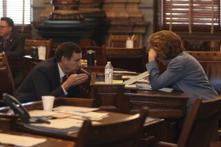 El senador estatal Dennis Pyle habla con la senadora estatal Brenda Dietrich durante una sesión del Senado, el viernes 5 de abril de 2024, en Topeka, Kansas. (AP Foto/John Hanna)