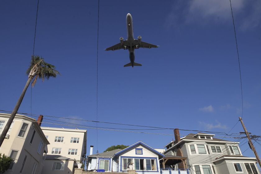 Hayne Palmour IV  U-T A passenger jet flies over houses on Albatross Street near downtown San Diego as it comes in for a landing at the San Diego International Airport on Friday.