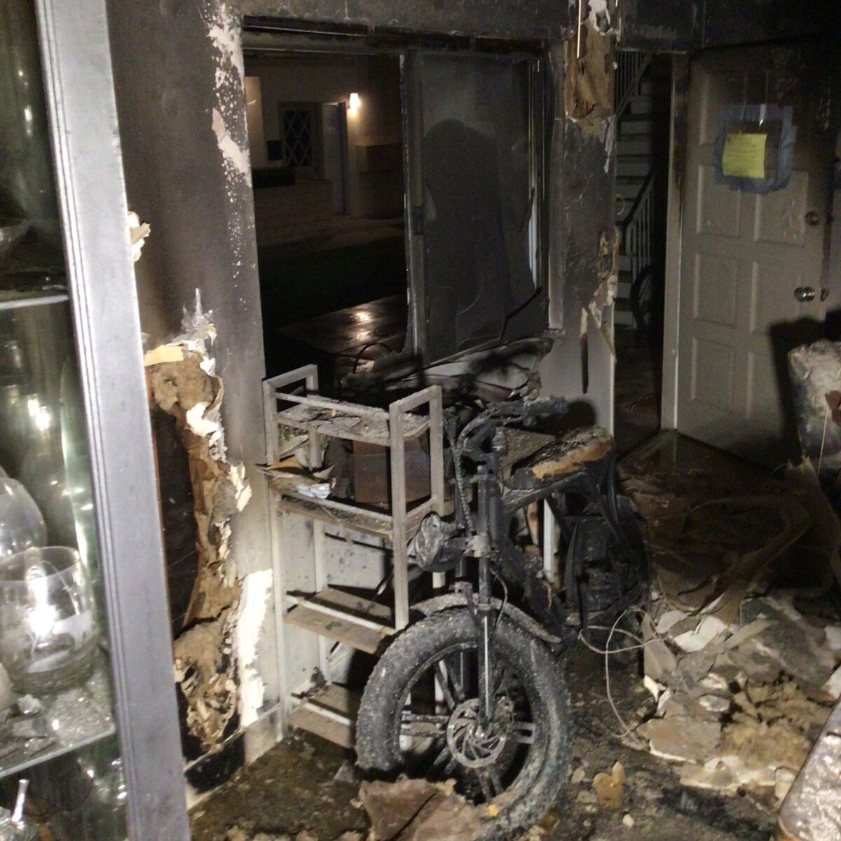 A burnt-out apartment with a blackened e-bike in the center.