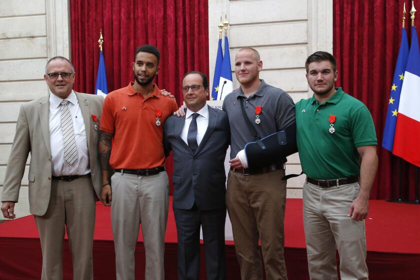 French President Francois Hollande, center, stands with, from left, British businessman Chris Norman and Americans Anthony Sadler, Spencer Stone and Alek Skarlatos, who subdued a gunman aboard a train. The four were awarded the Legion of Honor medal at the Elysee Palace on Aug. 24.