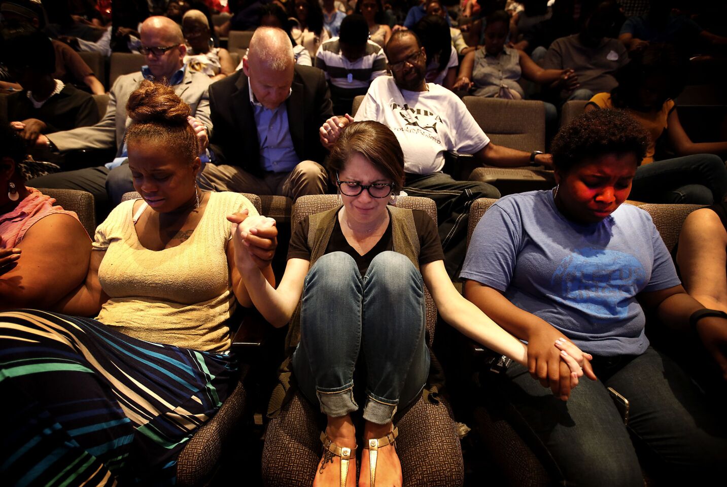 Stacy Powell, center, prays with others at the Concord Church in Dallas following the police shooting.