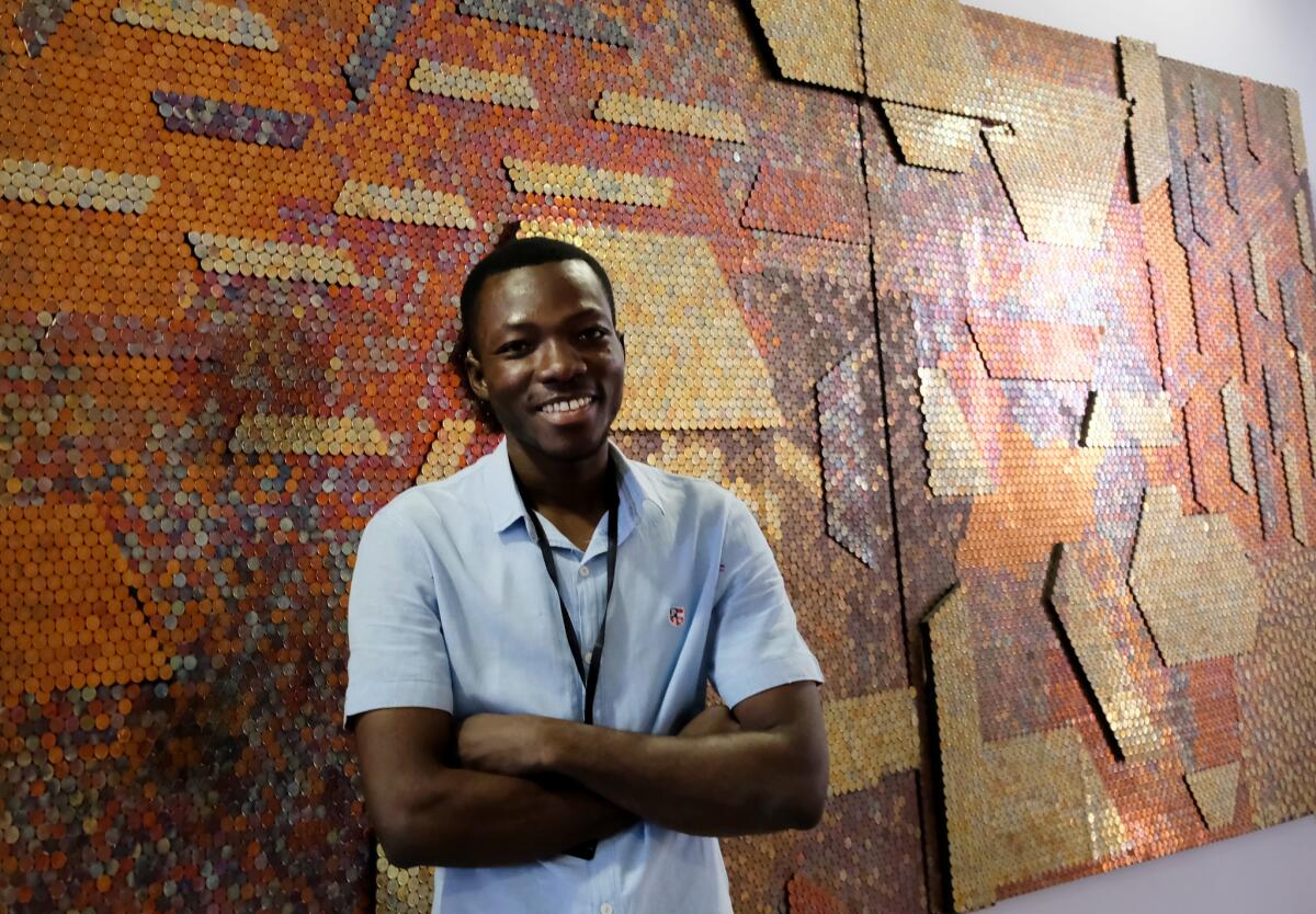 Yaw Owusu, a Ghanaian artist, stands in front of his work at Art X Lagos in November 2017.