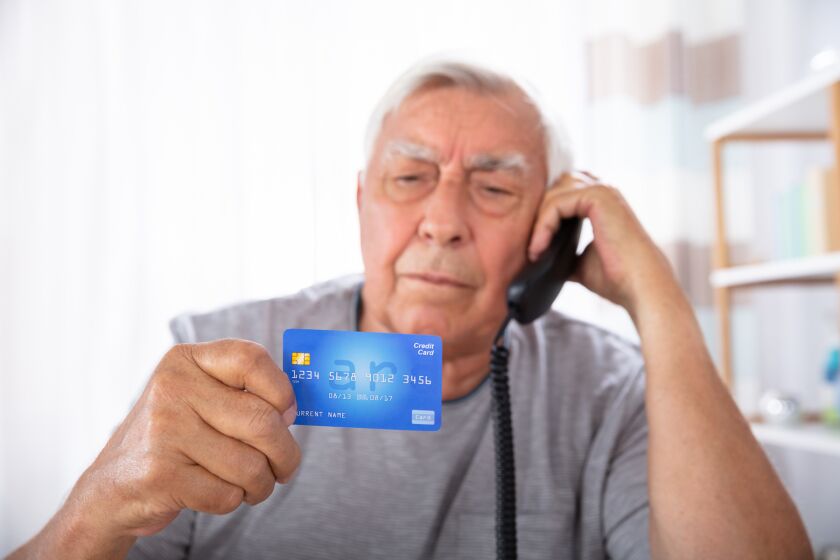 elderly man on phone with credit card