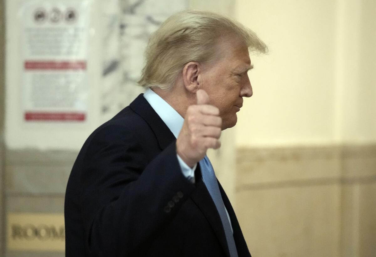 Former President Trump gives a thumbs-up.