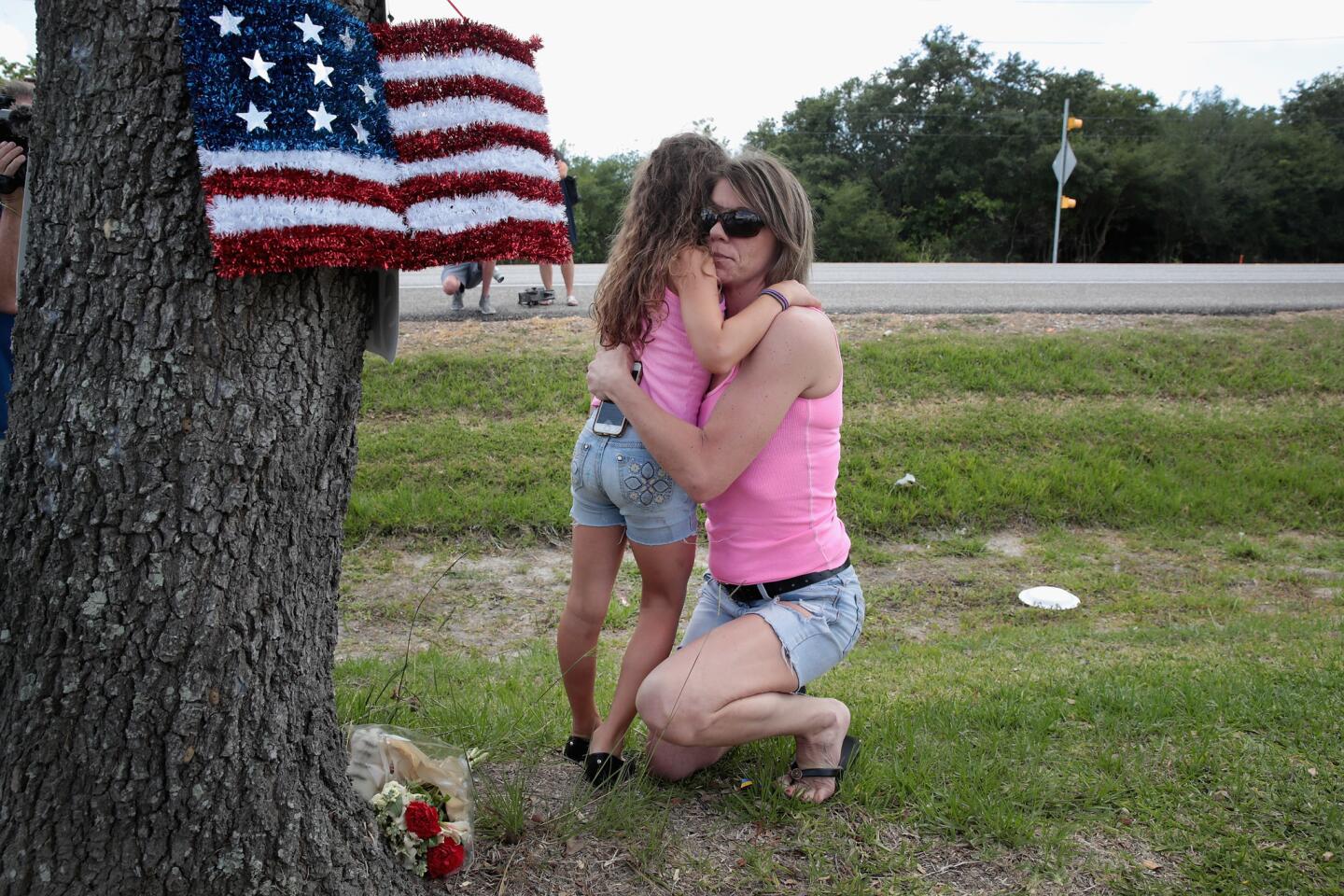 Carissa Potts hugs her 7-year-old daughter Kaylee after leaving flowers at a small memorial outside of Santa Fe High School on May 19, 2018, in Santa Fe, Texas.
