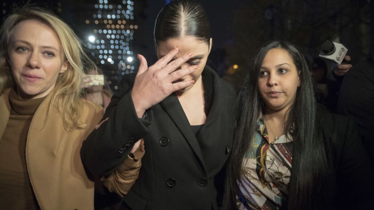 Emma Guzman, "El Chapo's" wife, ducks her head in the media scrum outside the courthouse.
