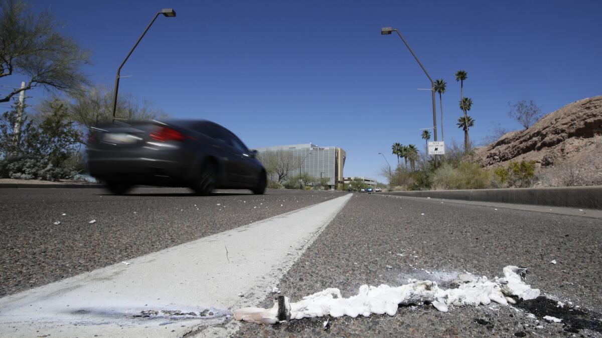 Cars on Monday pass the scene in Tempe, Ariz., where a pedestrian was fatally stuck by an Uber vehicle in autonomous mode.
