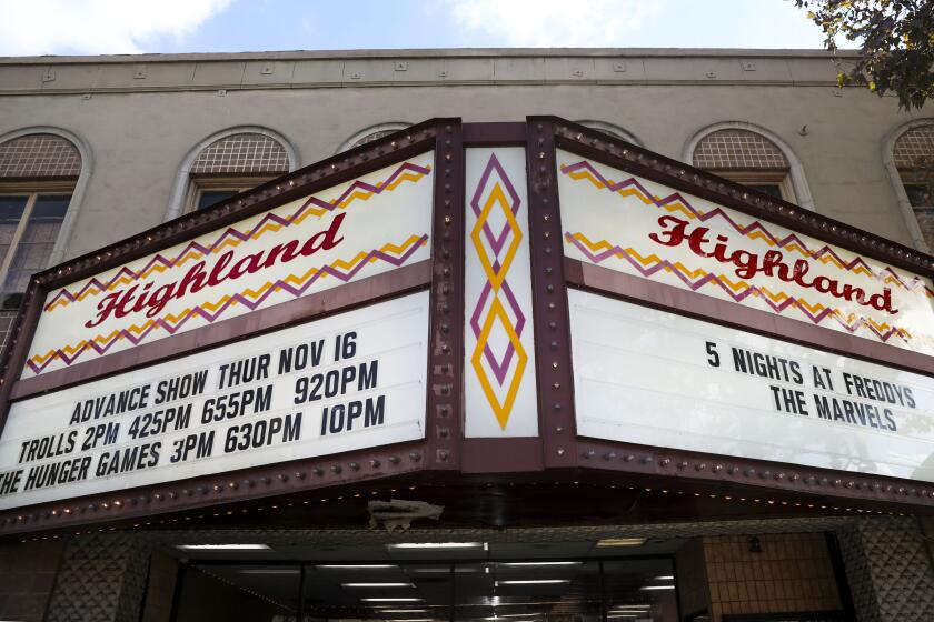 An old-fashioned movie theater marquee that reads "Highland" and displays showtimes for various titles