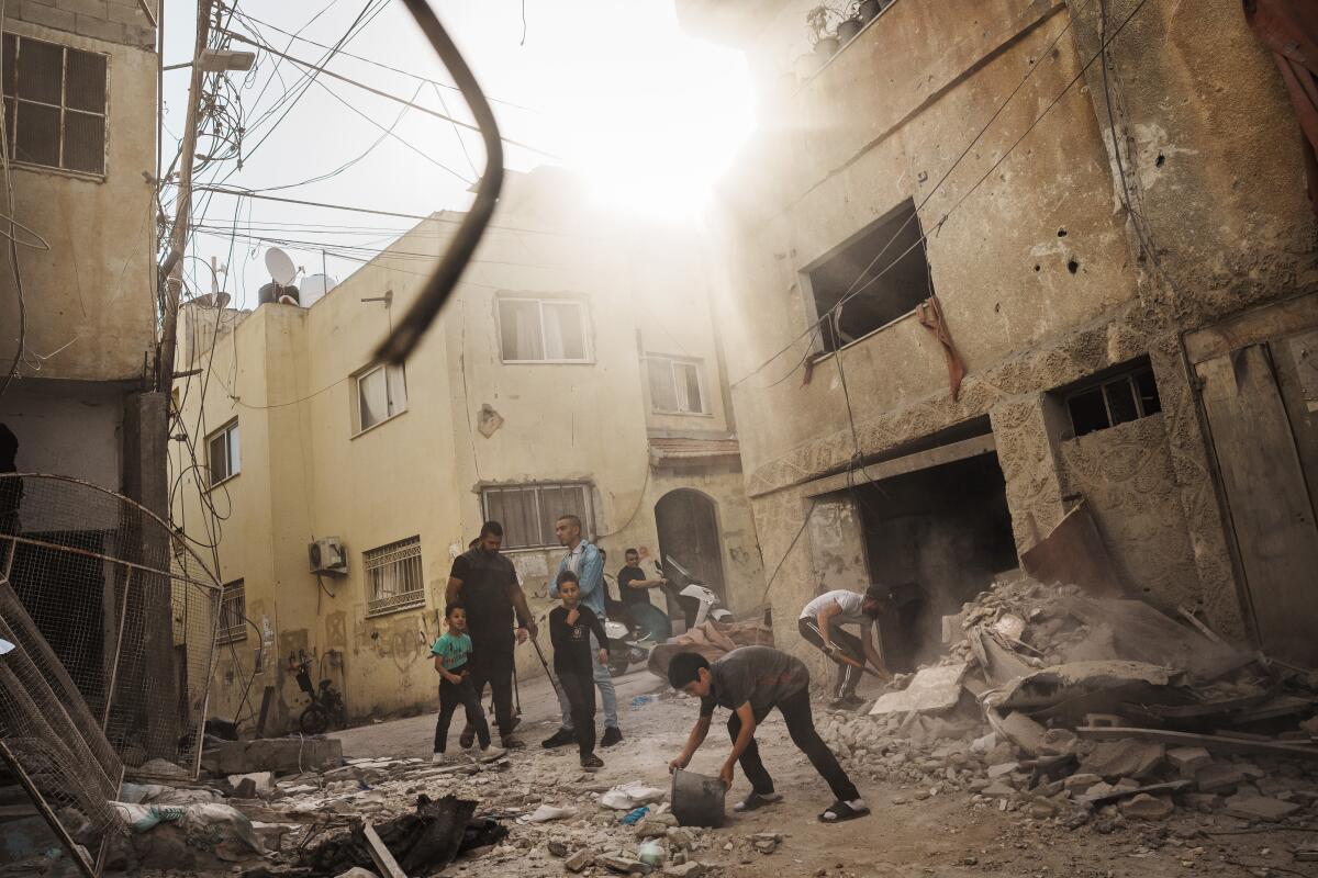 Residents examine the aftermath of an Israeli airstrike on the Al Ansar Mosque