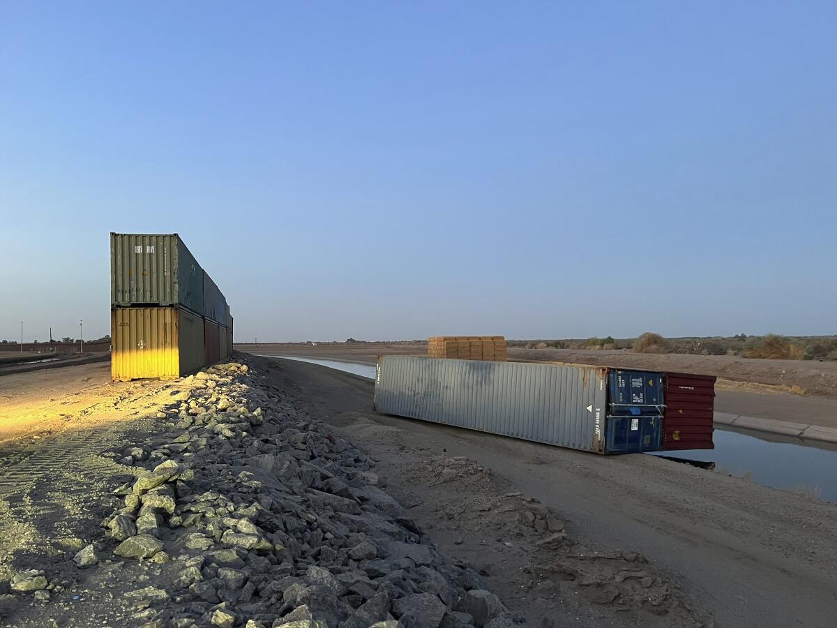 Esta foto proporcionada por Univision Arizona muestra contenedores de carga vacíos derribados 