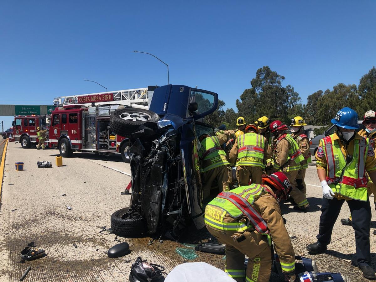 Costa Mesa firefighters use the jaws of life Thursday to pull a woman trapped inside her vehicle on the 55 Freeway.