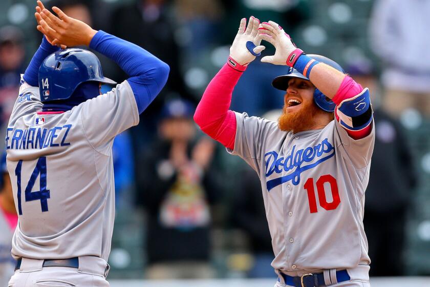 Dodgers third baseman Justin Turner (10) celebrates his pinch-hit, two-run home run against the Rockies with teammate Enrique Hernandez in the eighth inning Sunday at Coors Field.