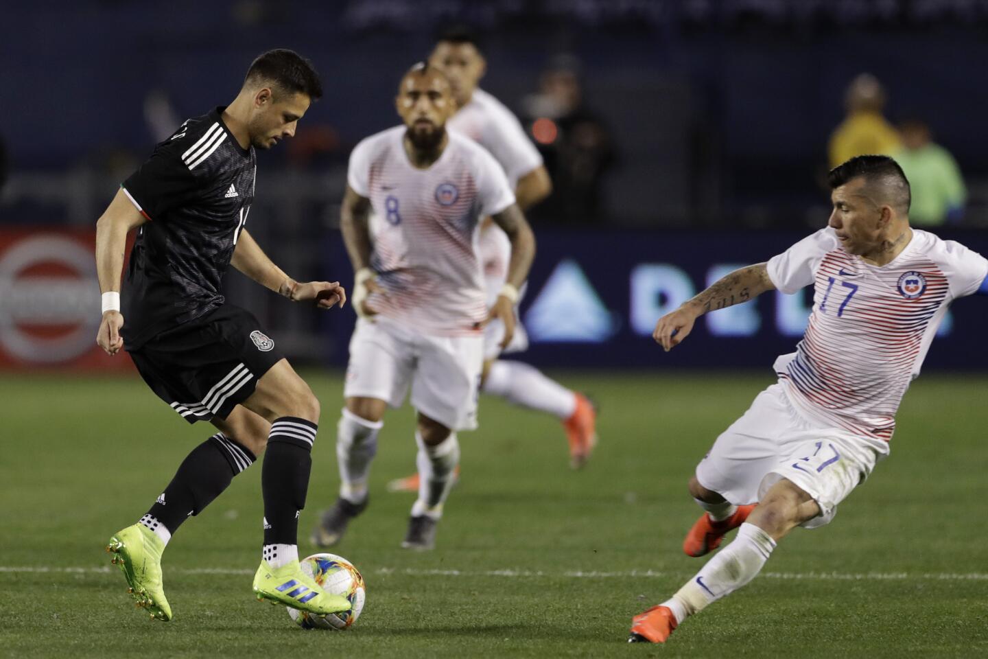 Mexico's Javier Hernandez, left, dribbles the ball as Chile's Gary Mendel, right, defends during the second half of an international friendly soccer match Friday, March 22, 2019, in San Diego. (AP Photo/Gregory Bull)