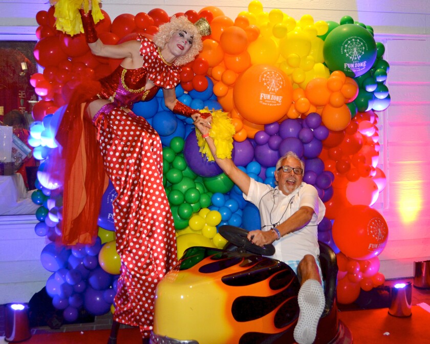 Stilt walker, SuzE-Q hams it up with Dennis Bress during the Balboa Island Museum Fun Zone Festival Friday night.