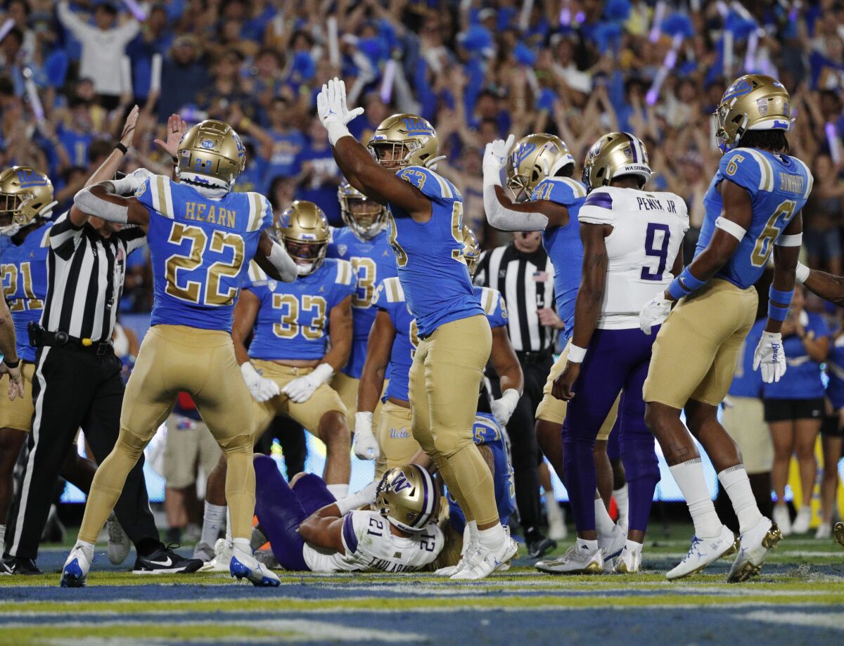 UCLA's Darius Muasau gestures for a safety call after Washington's Wayne Taulapapa was tackled in the end zone