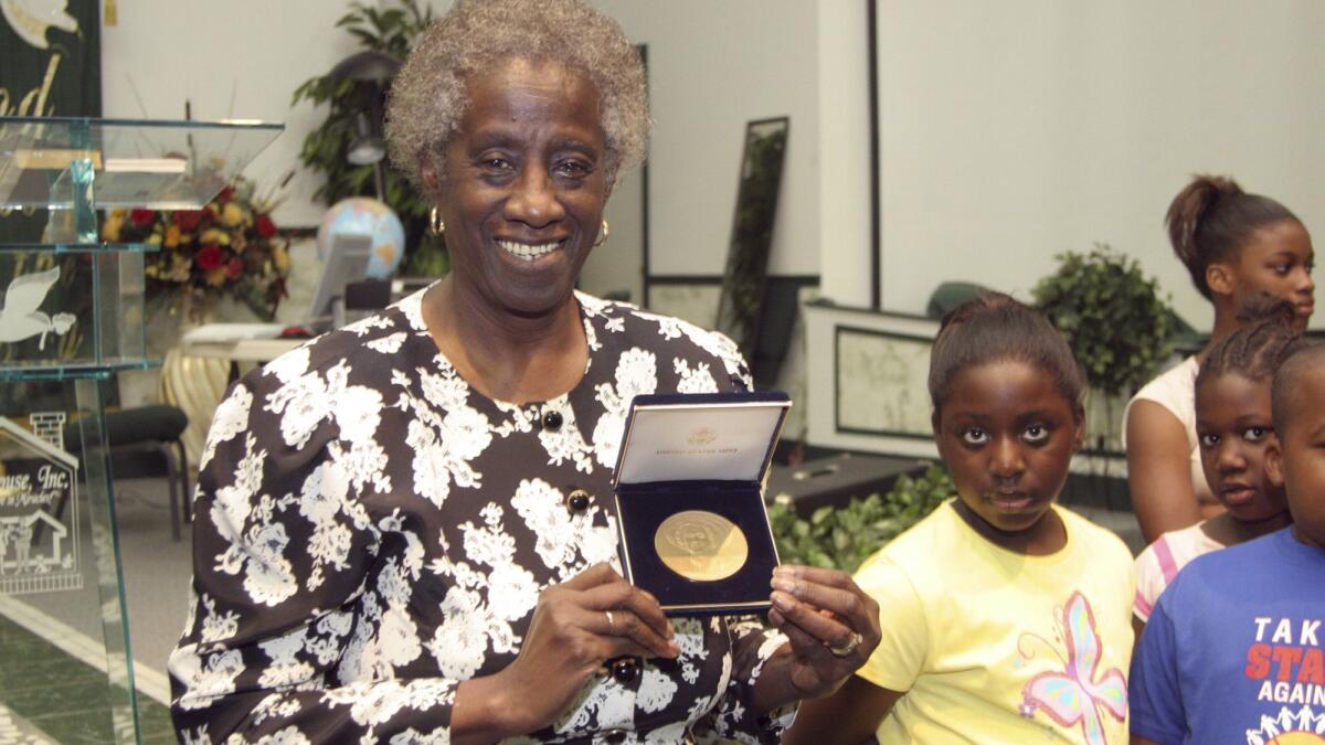Unita Blackwell, the first black woman elected mayor in Mississippi, shows an audience the gold-minted coin given to her in recognition of her pioneering struggles for voting rights in 2006.